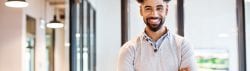 smiling african american male in white shawl sweater with his arms folded and smiling