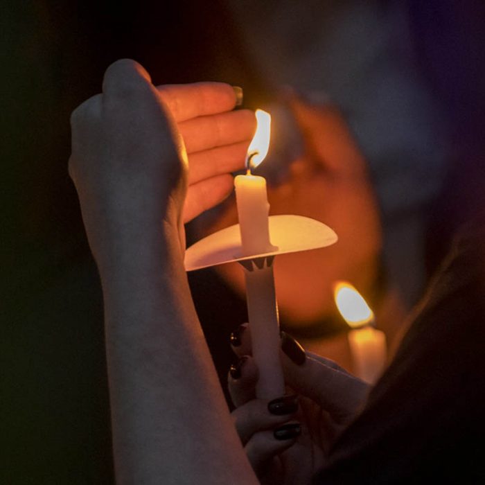 UofL-Studentenhände, die eine Kerze während einer Sammlung Take Back the Night halten