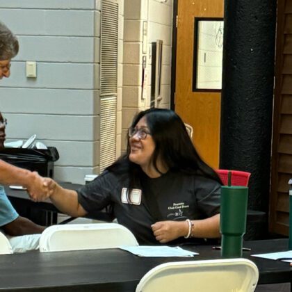 A faculty member speaks to new students at an open house event