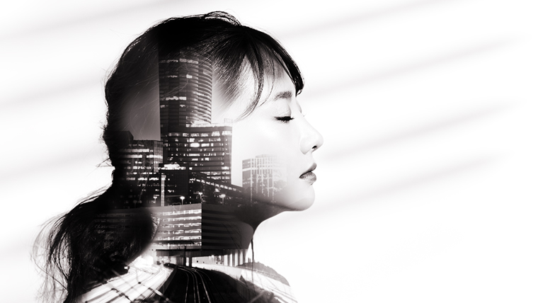 A double exposure of a young asian woman's side profile with the Atlanta skyline set within it.