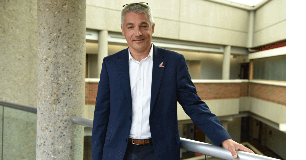 Sergey Anokhin, PhD, stands in front of a railing in Frazier Hall