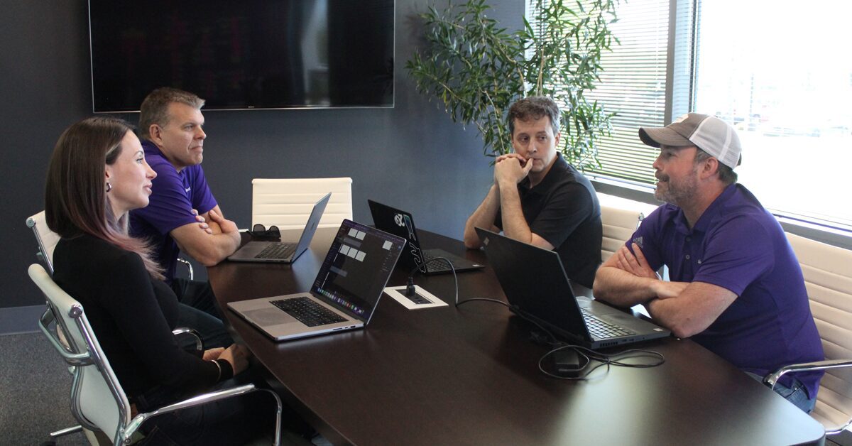 Slingshot staff discuss project around a conference table