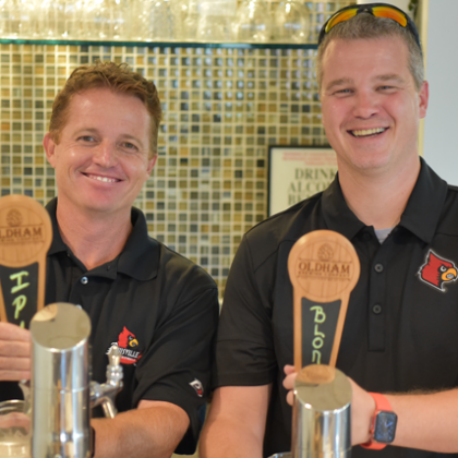 来自 Oldham County Brewing 的 Brad Conrad 和 Steve Cayton 在酒吧后面经营啤酒龙头。