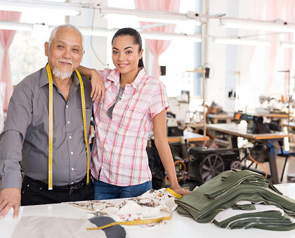 Father and daughter in textile factory, family business legacy in studio.