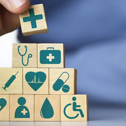 Men's hand arranging wood blocks with healthcare medicine icons