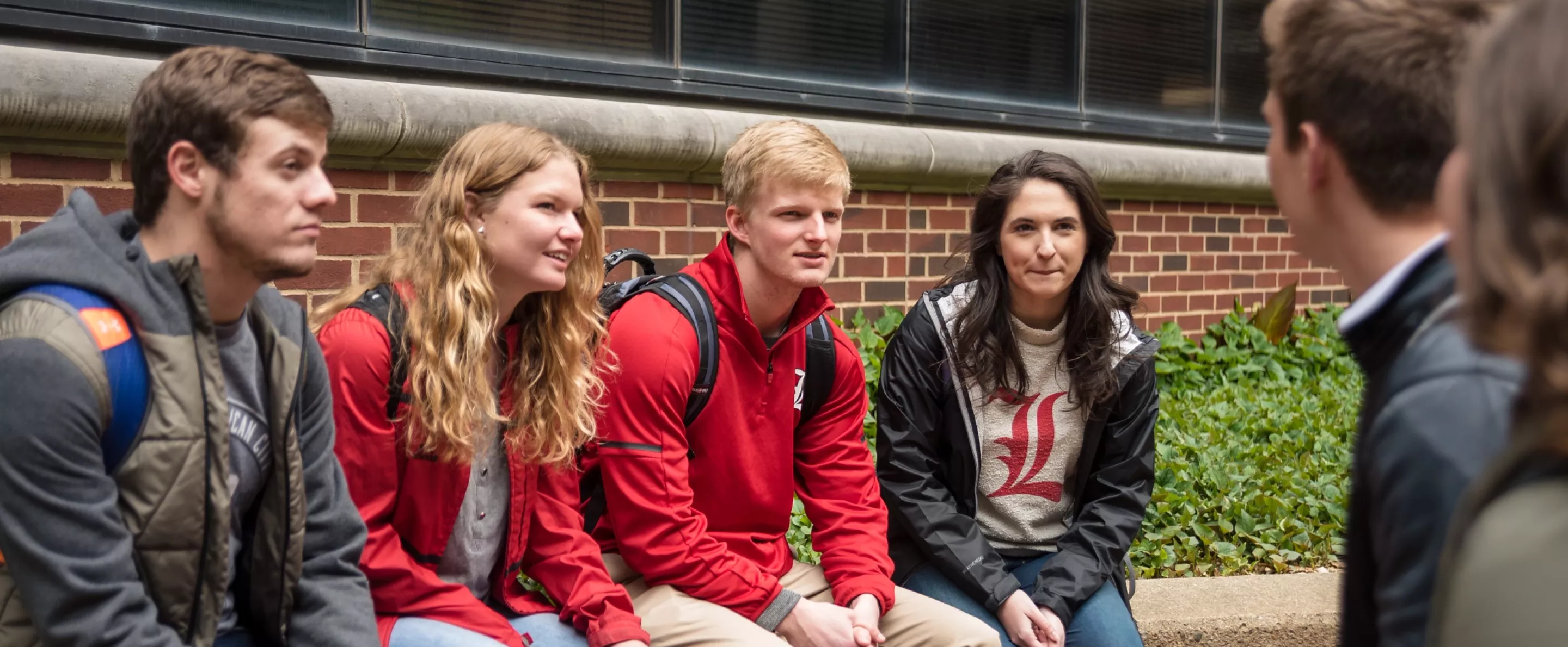 Students sit outside the College of Business