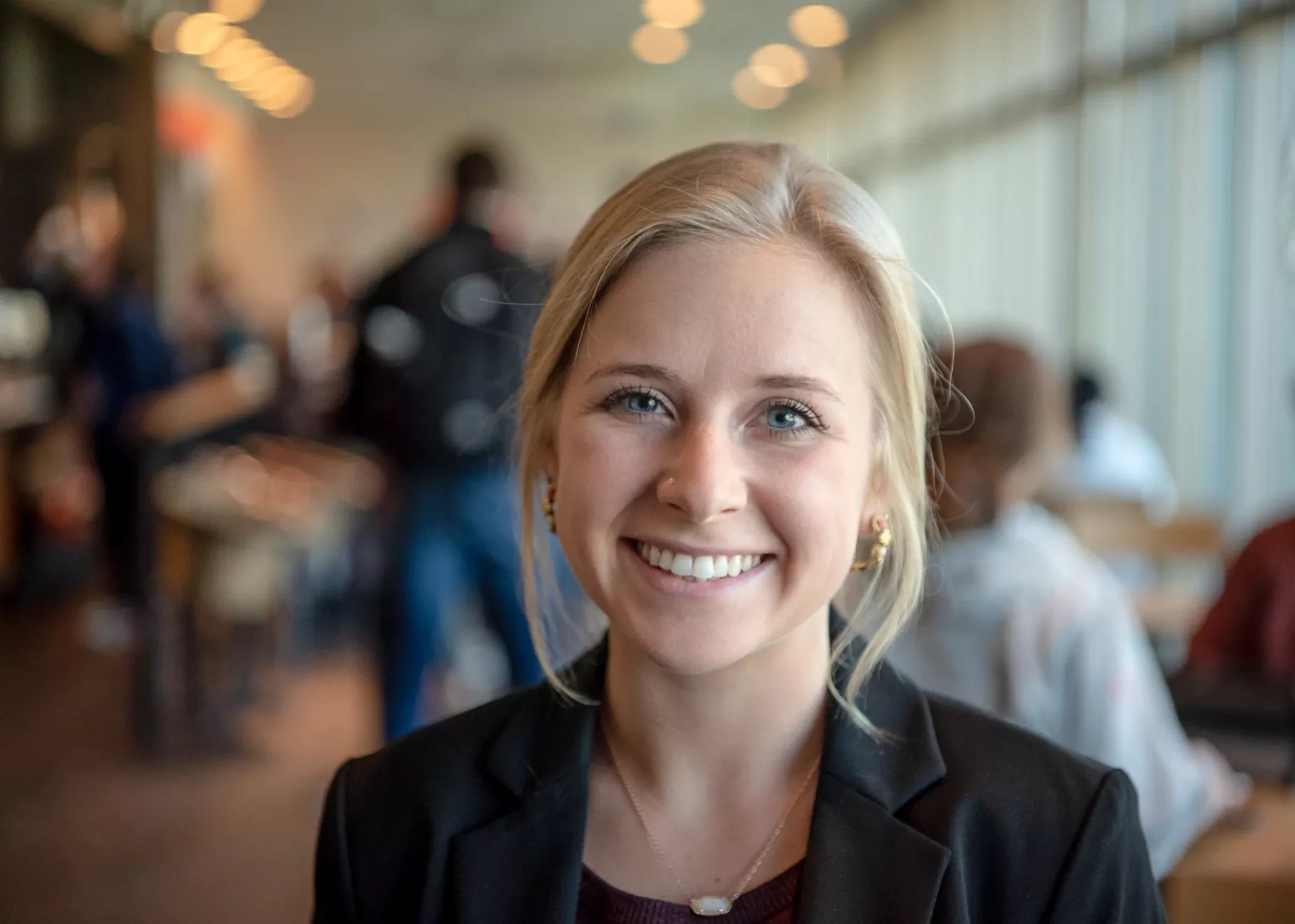 Student portrait smiling in a busy cafe on campus