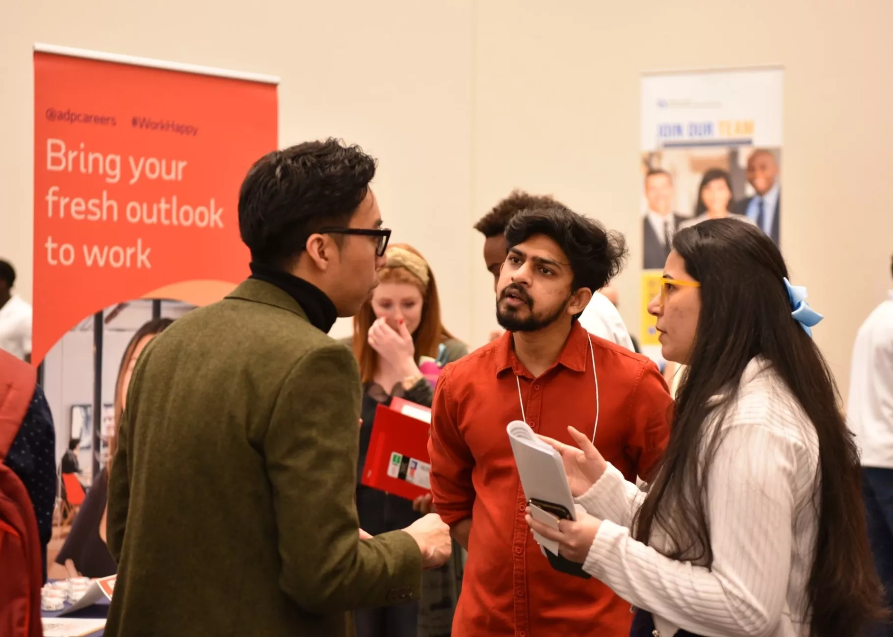 Students having engaging discussion with ADP Campus Recruiter Alfred Posis