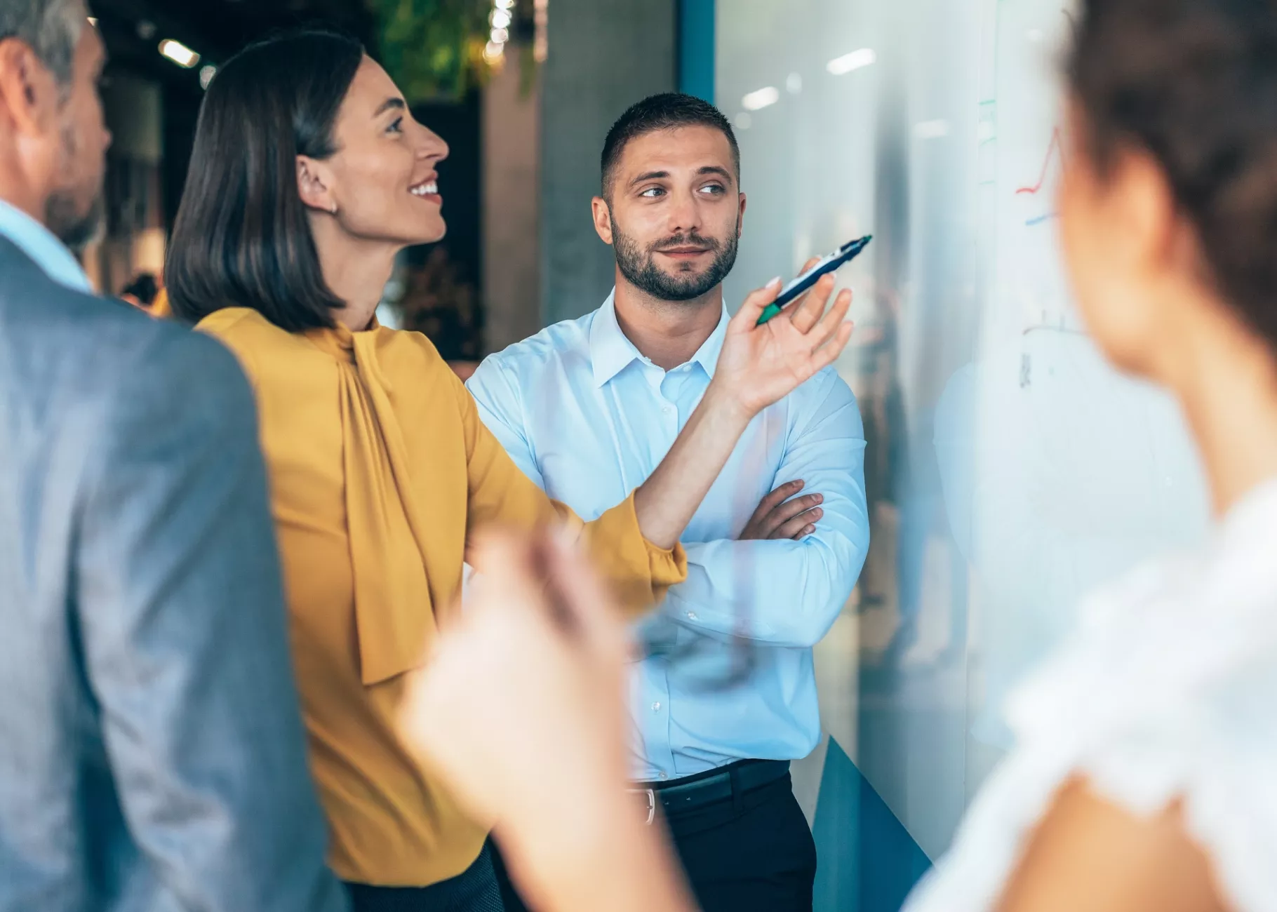Coworkers brainstorming and writing on a whiteboard