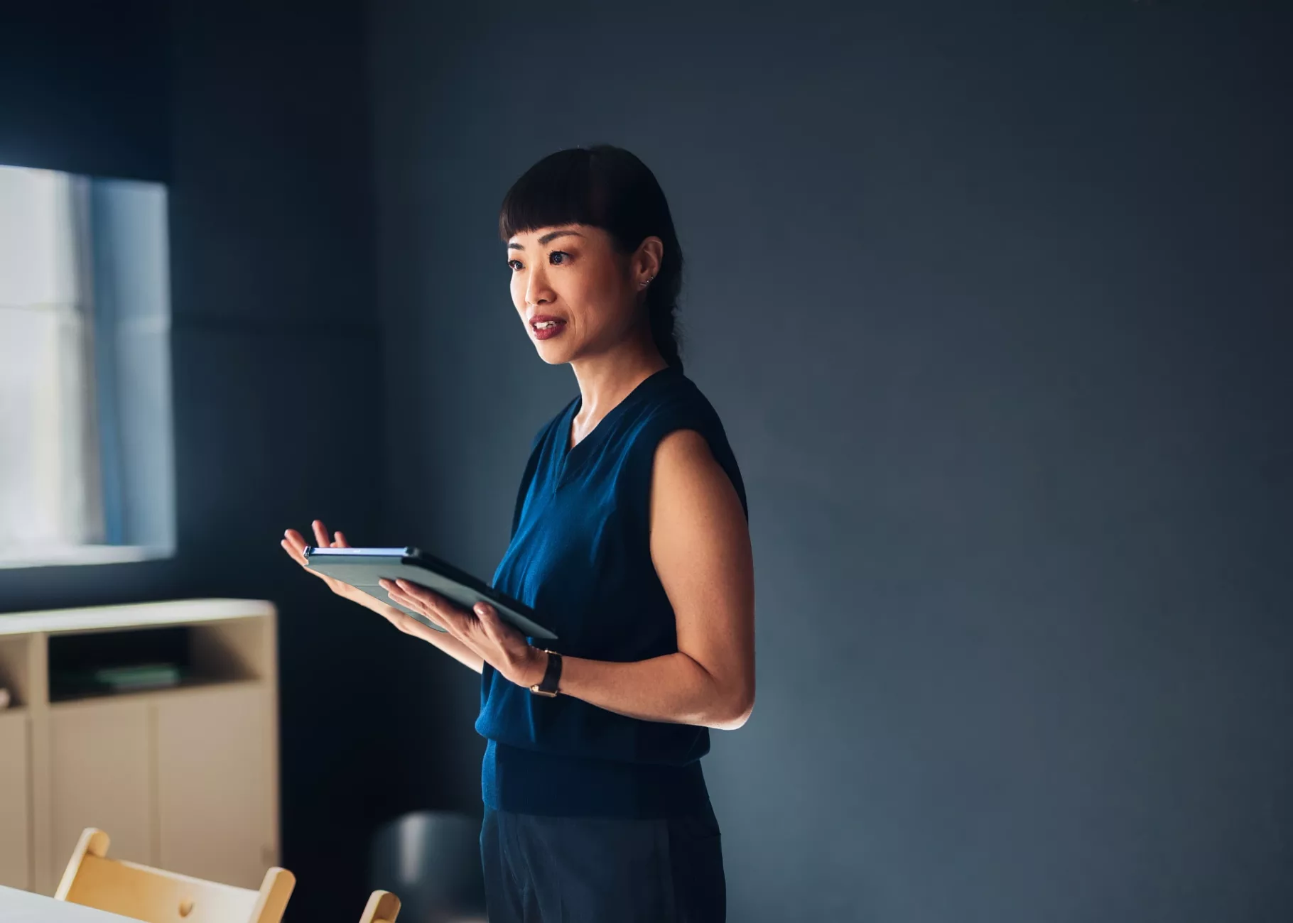 Woman holding a tablet giving a presentation