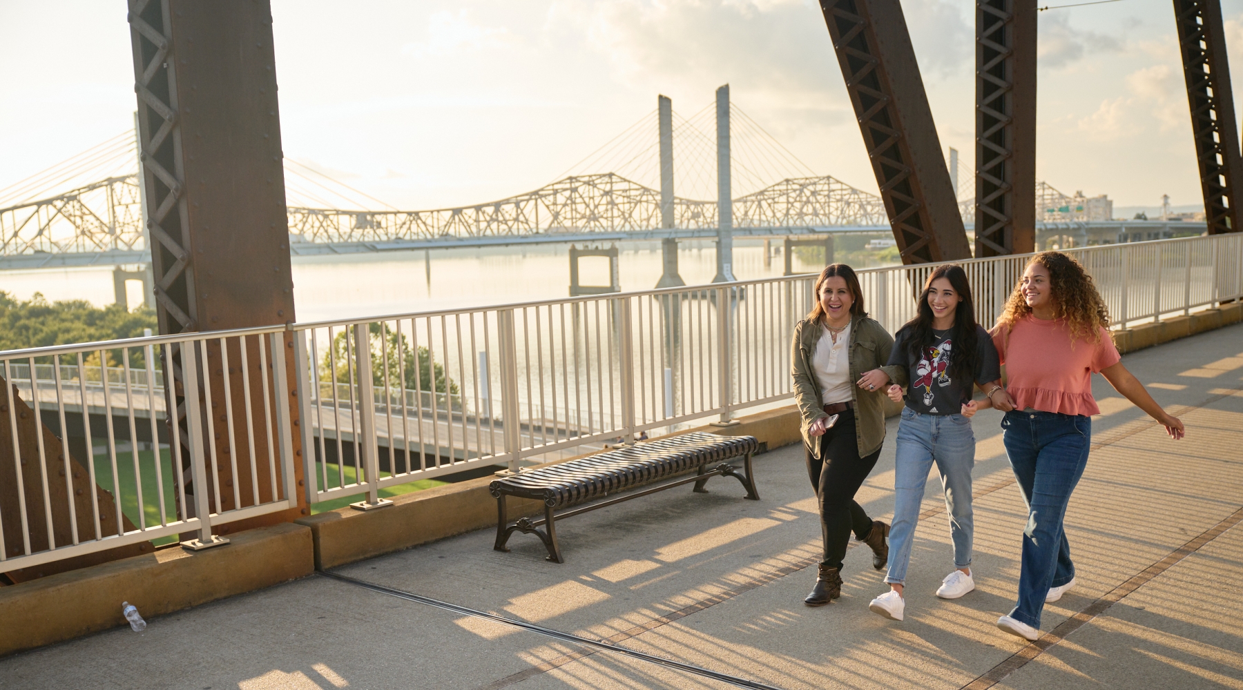 Three students walking and talking on the Big Four Bridge at Waterfront Park in downtown Louisville.