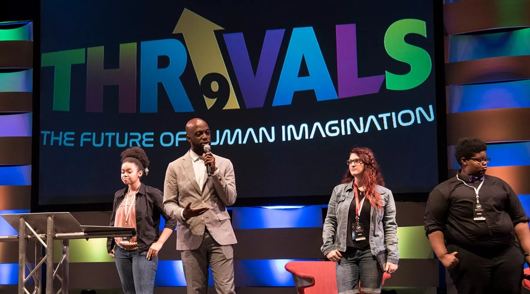 Four Thrivals event speakers on stage giving a talk.