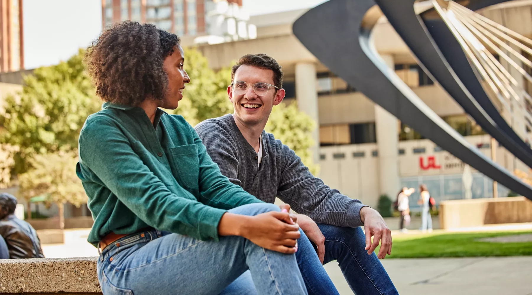 Two students have a pleasant conversation with each other in the HSC courtyard.
