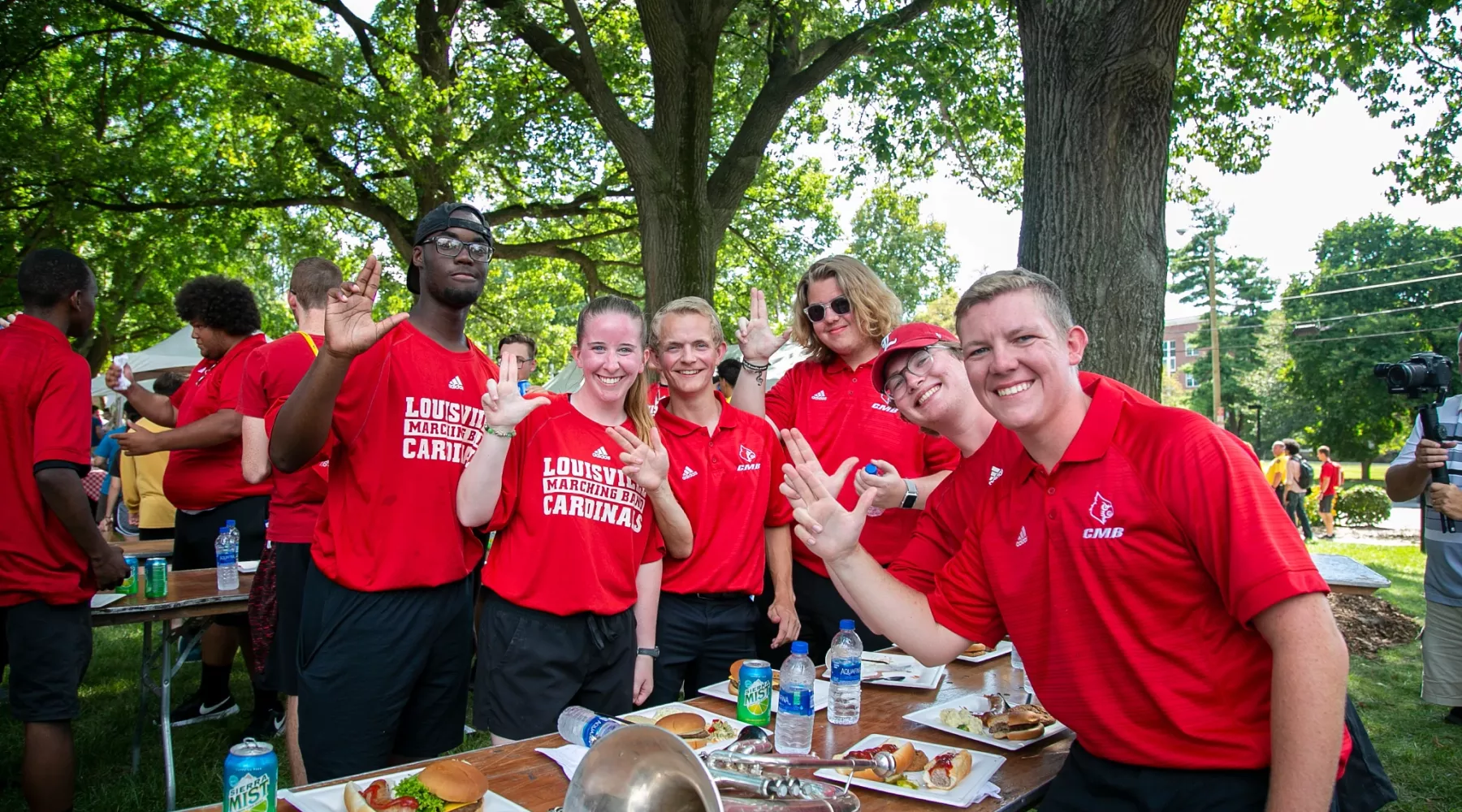 Members of the Cardinal Marching Band pose for a picture holding up their Ls.