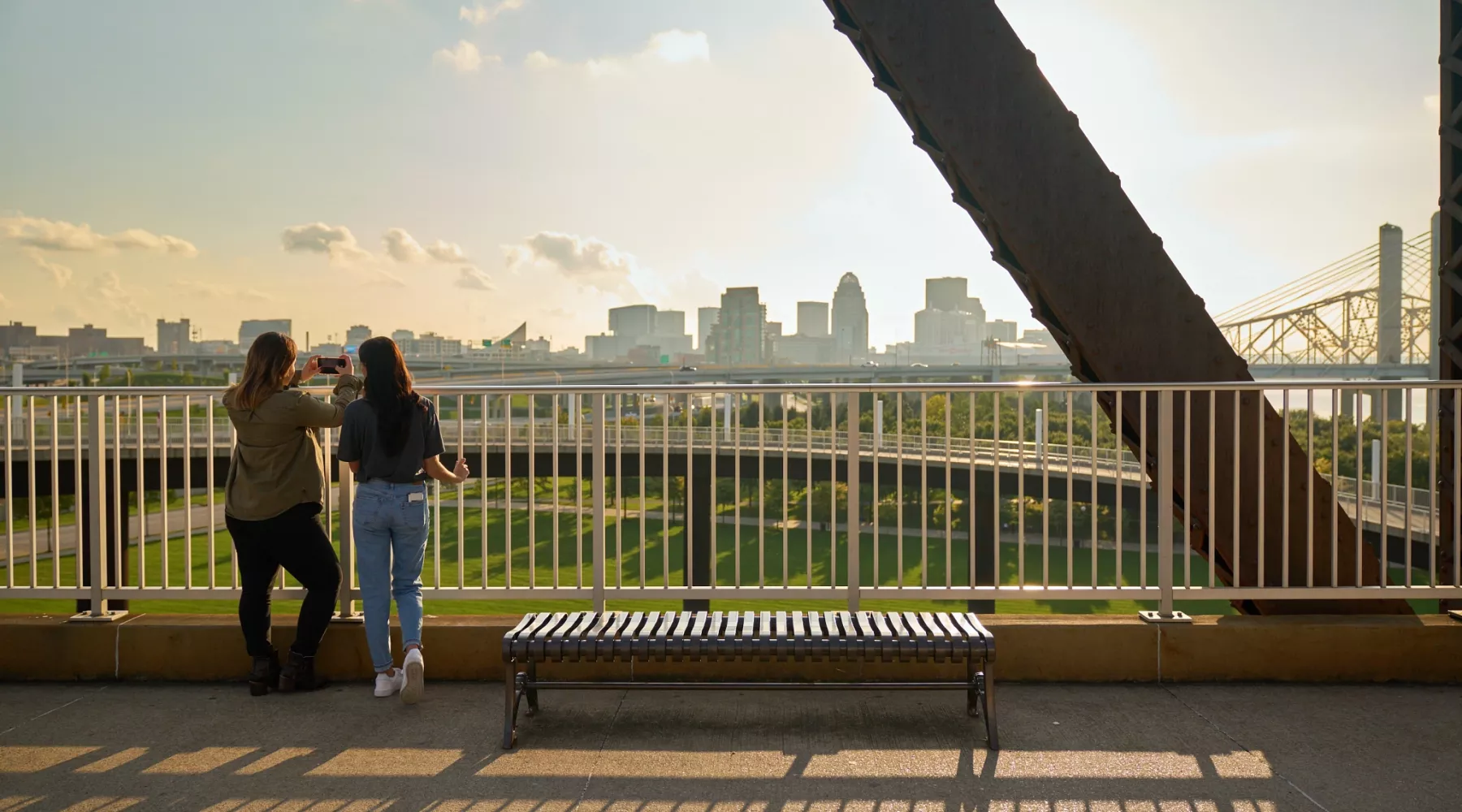 Two students looking at the Louisville skyline from the Big Four Bridge at Waterfront Park in downtown Louisville.