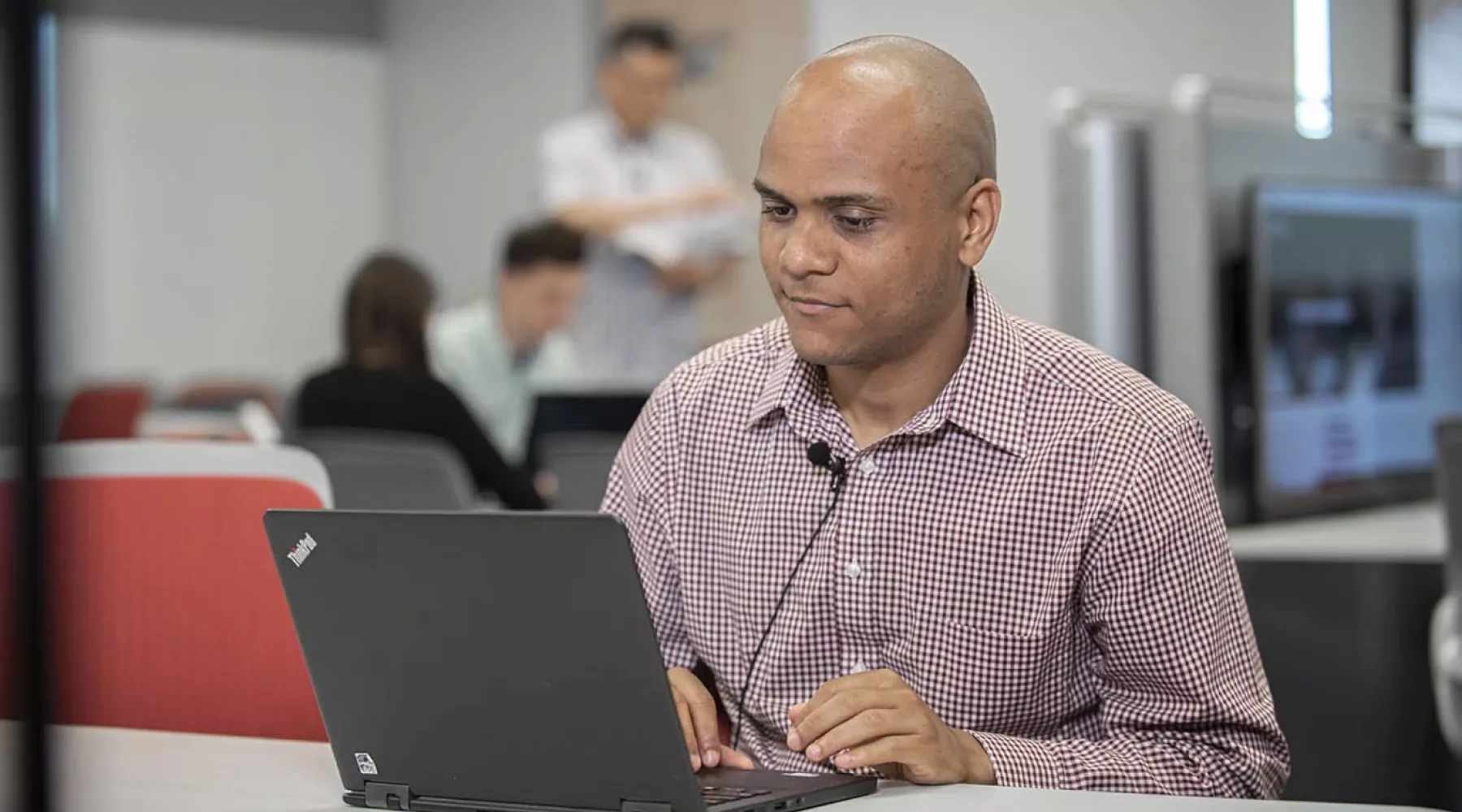 A man working on a laptop computer during class in the College of Business