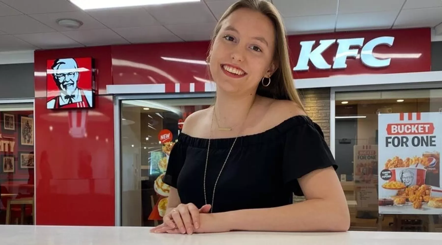 College of Business student, Dacia Berry in front of a Kentucky Fried Chicken restaurant