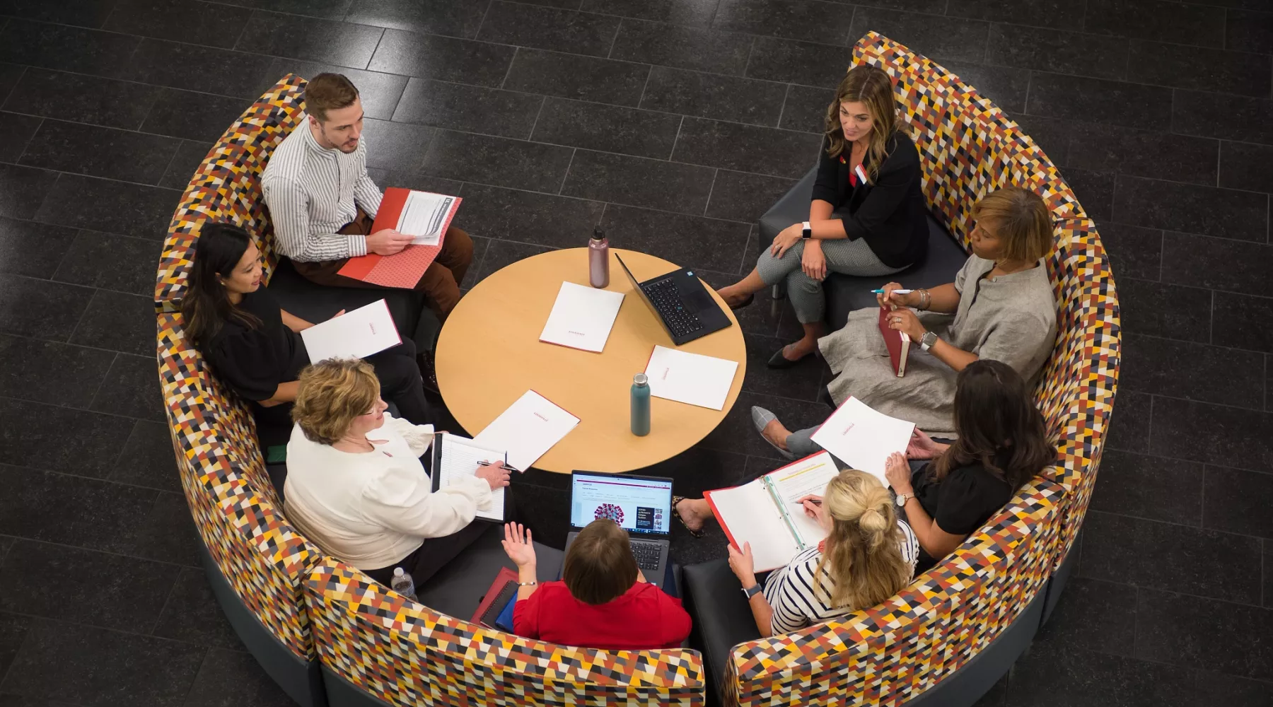 Group of employees having a conversation in a meeting while seated in the Belknap Academic Building