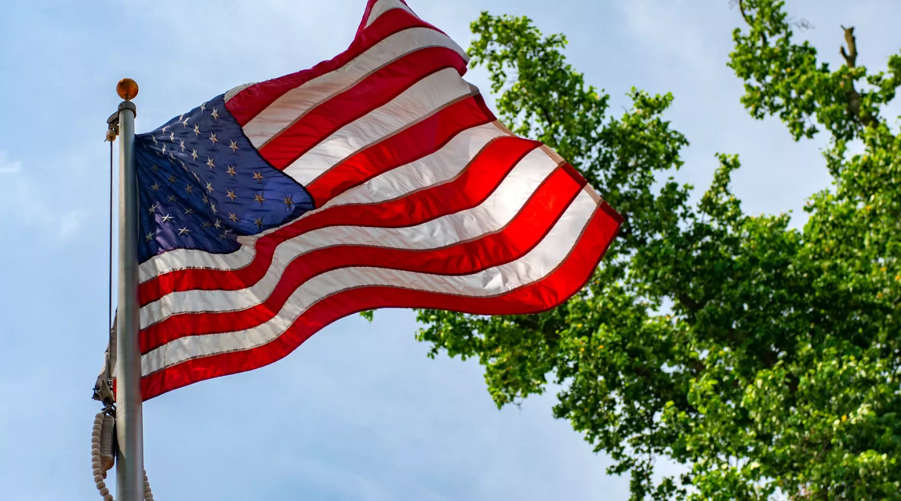 American flag waving in the wind on Belknap Campus