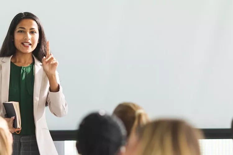 A woman in front of a classroom.