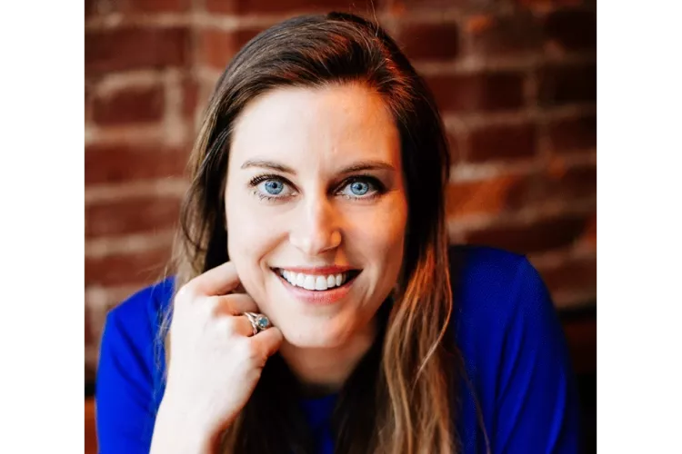 A woman resting her head against her knuckle.
