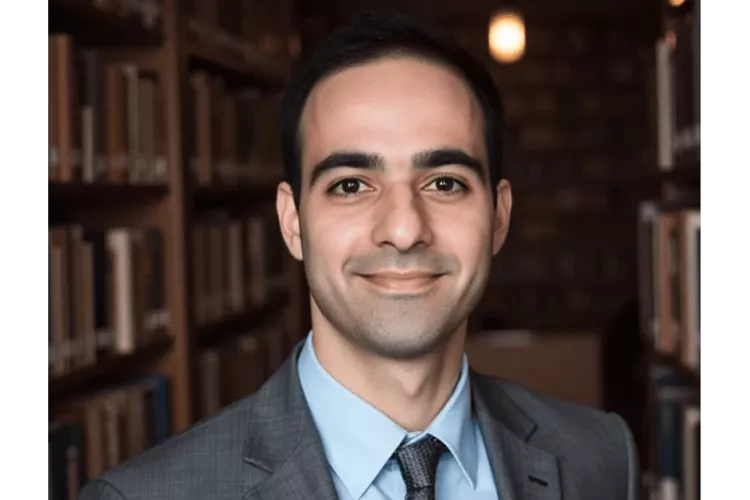 Danial Malik in grey suit posing for headshot