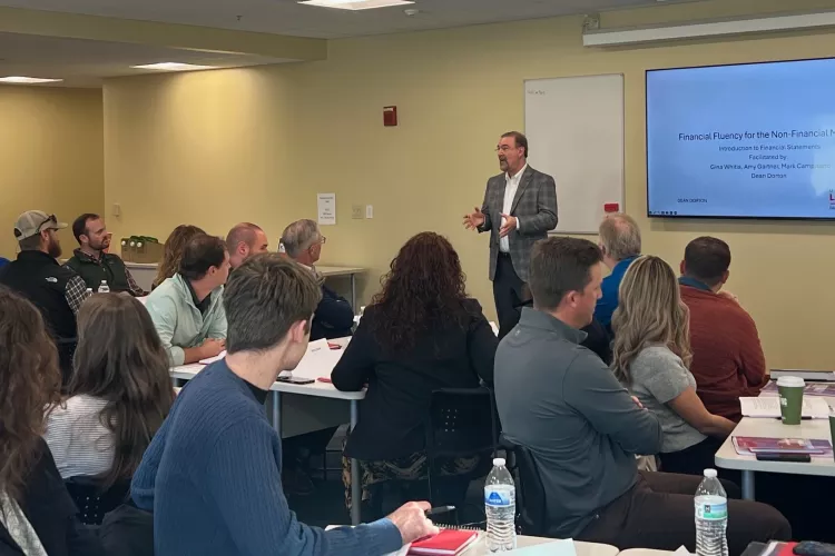 Man at the front of a classroom speaking.