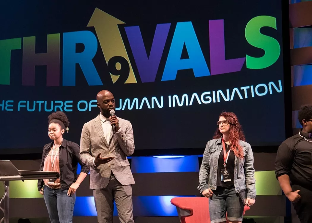 Four Thrivals event speakers on stage giving a talk.