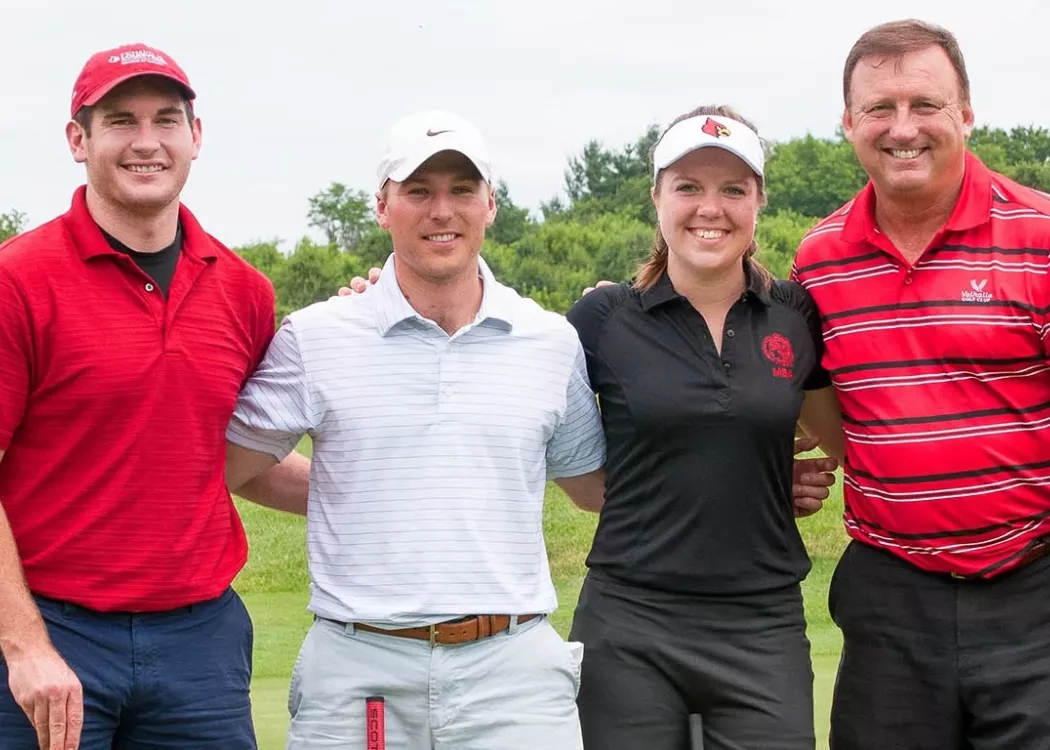 Four UofL College of Business alumni stand side by side at a golf outing.