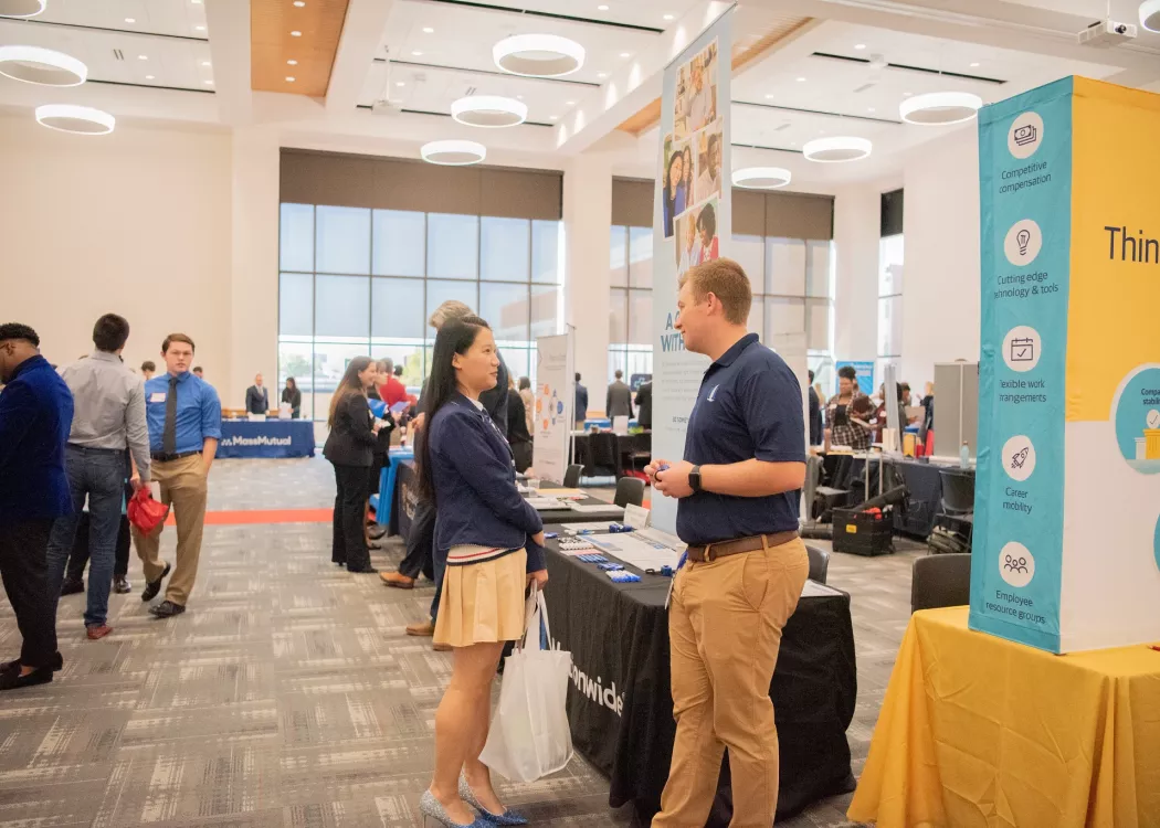 A female student and male recruiter engaging in conversation at COB Career Fair
