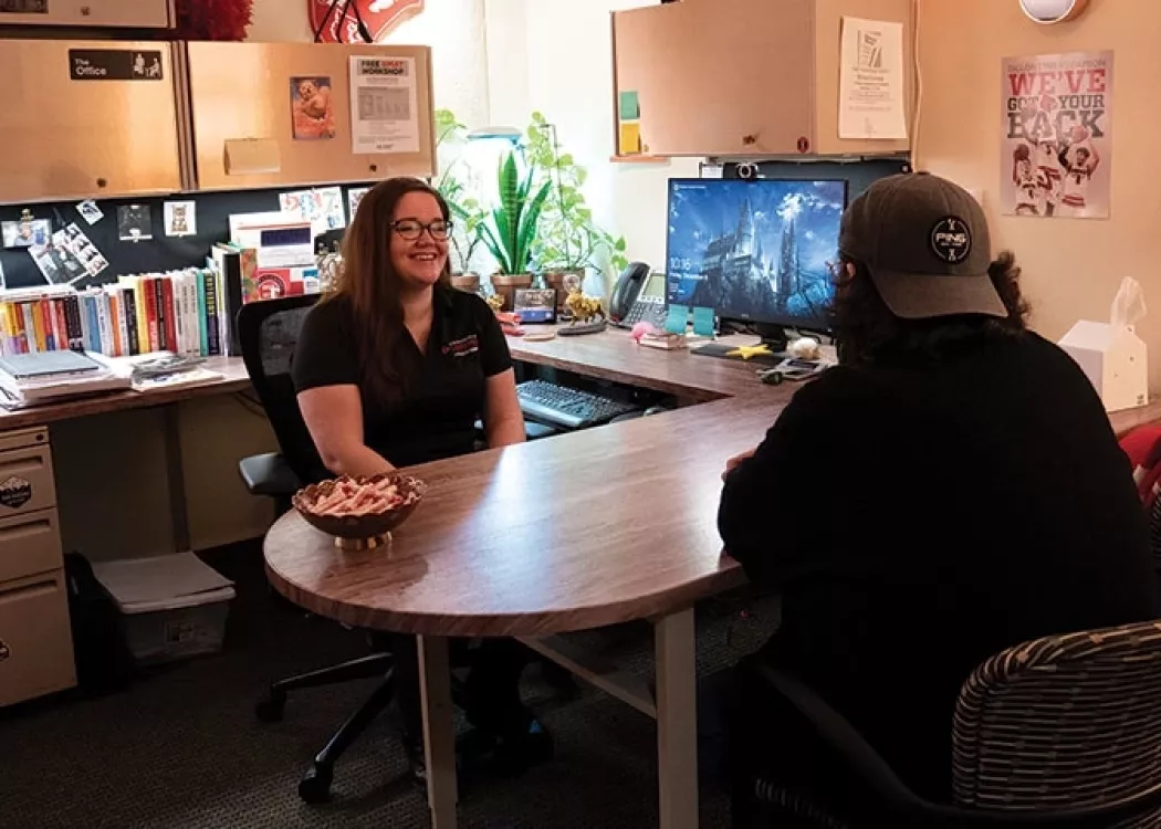 Academic Advisor/Student Success Coordinator having a meeting with a male student in their office