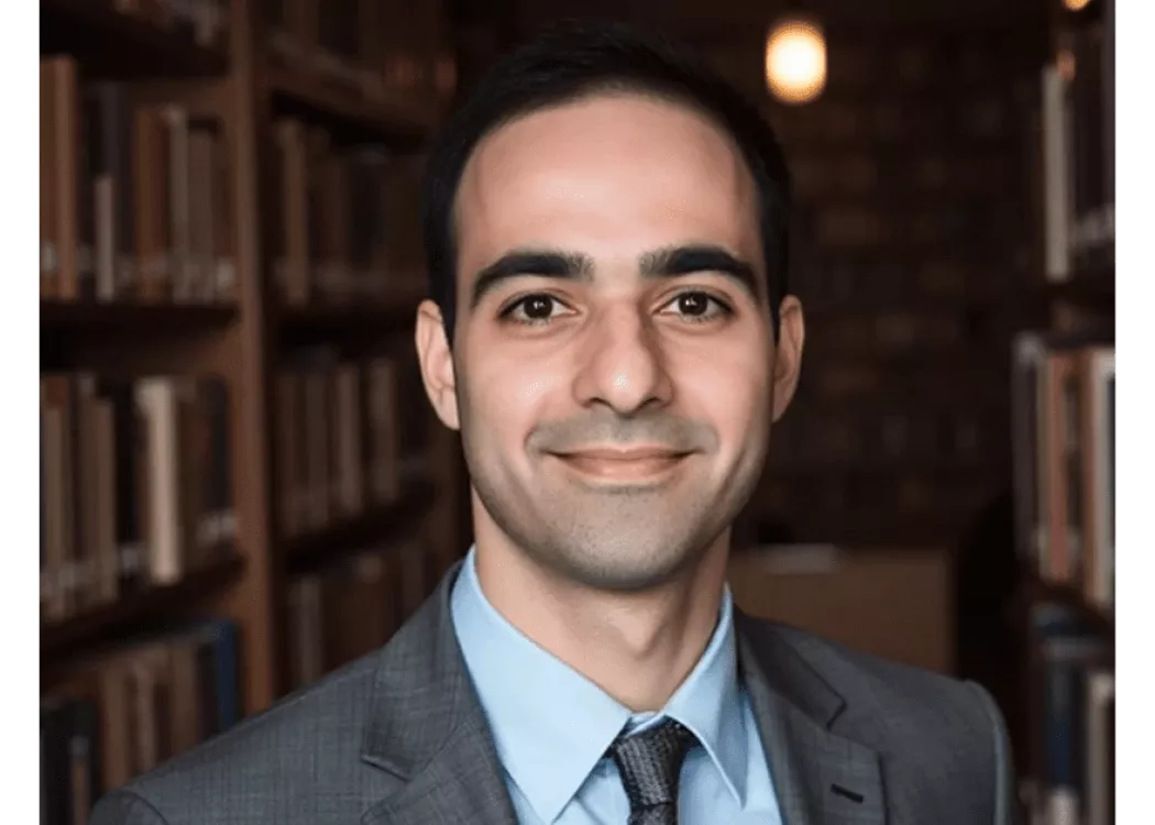 Danial Malik in grey suit posing for headshot