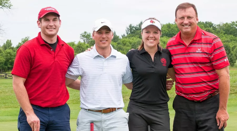 Four UofL College of Business alumni stand side by side at a golf outing.