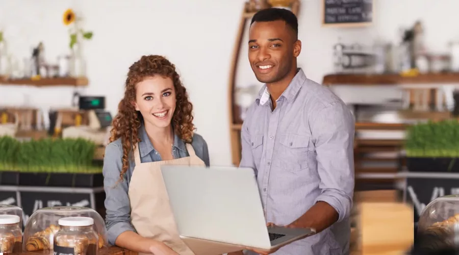 Two franchise or small business owners at work with a laptop at a cafe