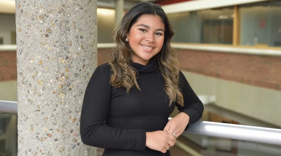 A woman resting her arm on a rail.