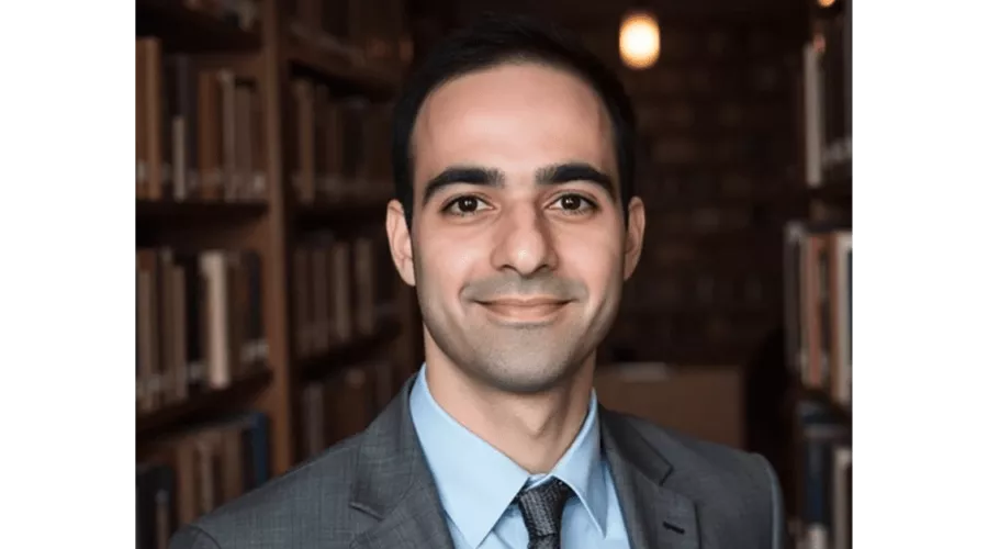 Danial Malik in grey suit posing for headshot