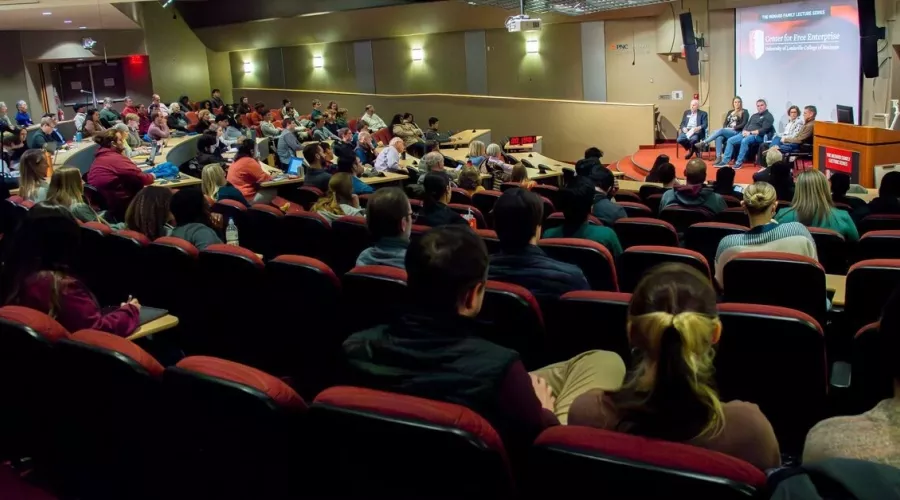 Group of people sitting in the Horn Auditorium watching a panelist event.