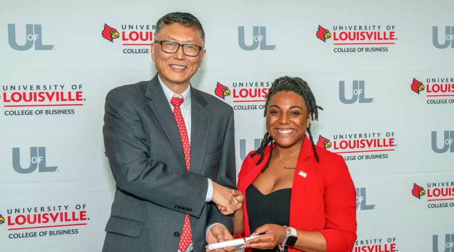UofL College of Business Fall22 PMBA student, Jomiya Coleman,  accepts diploma from Interim Dean, Jeff Guan, at the…
