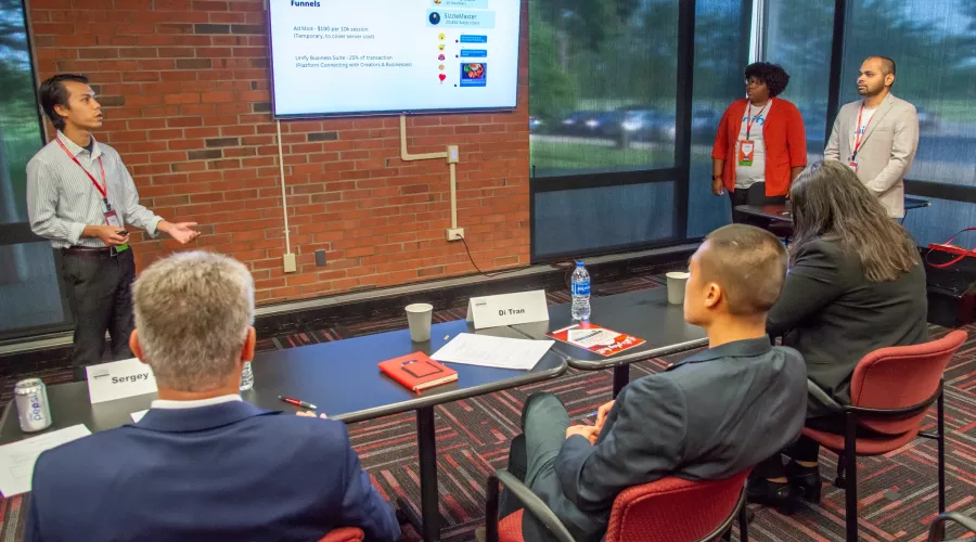 A group presenting a startup idea to judges at the Cardinal Challenge competition hosted by the Forcht Center for…