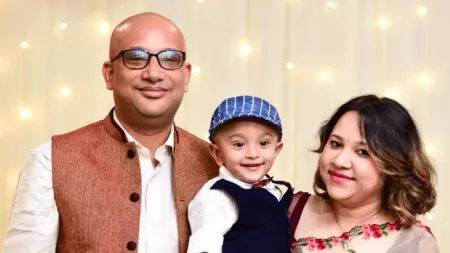 Family with two parents and one toddler posing for photo