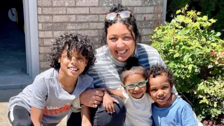 Mother posing with her three children on porch