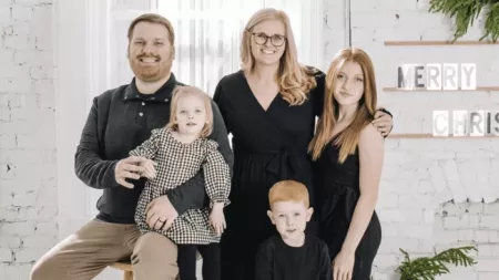 Mother posing with her husband and three children