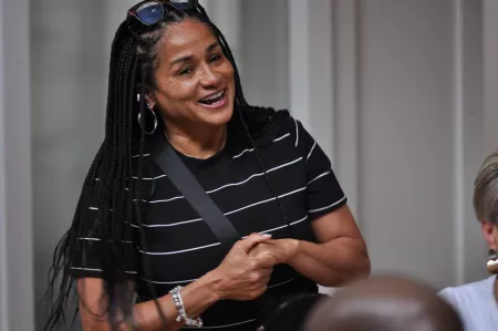 Woman smiling and speaking to a group of people